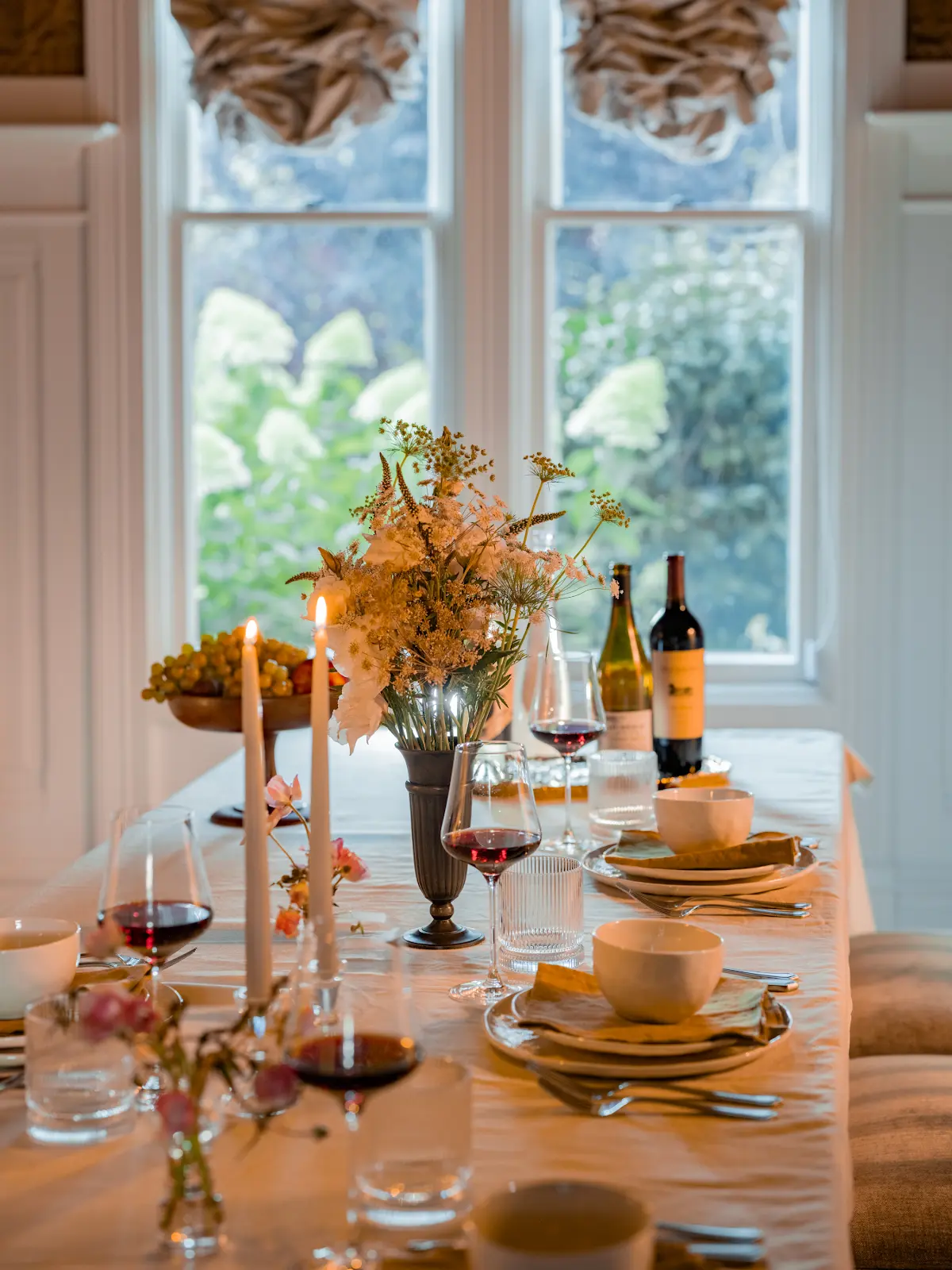 Wine and flowers arranged in the sunlit estate dining room