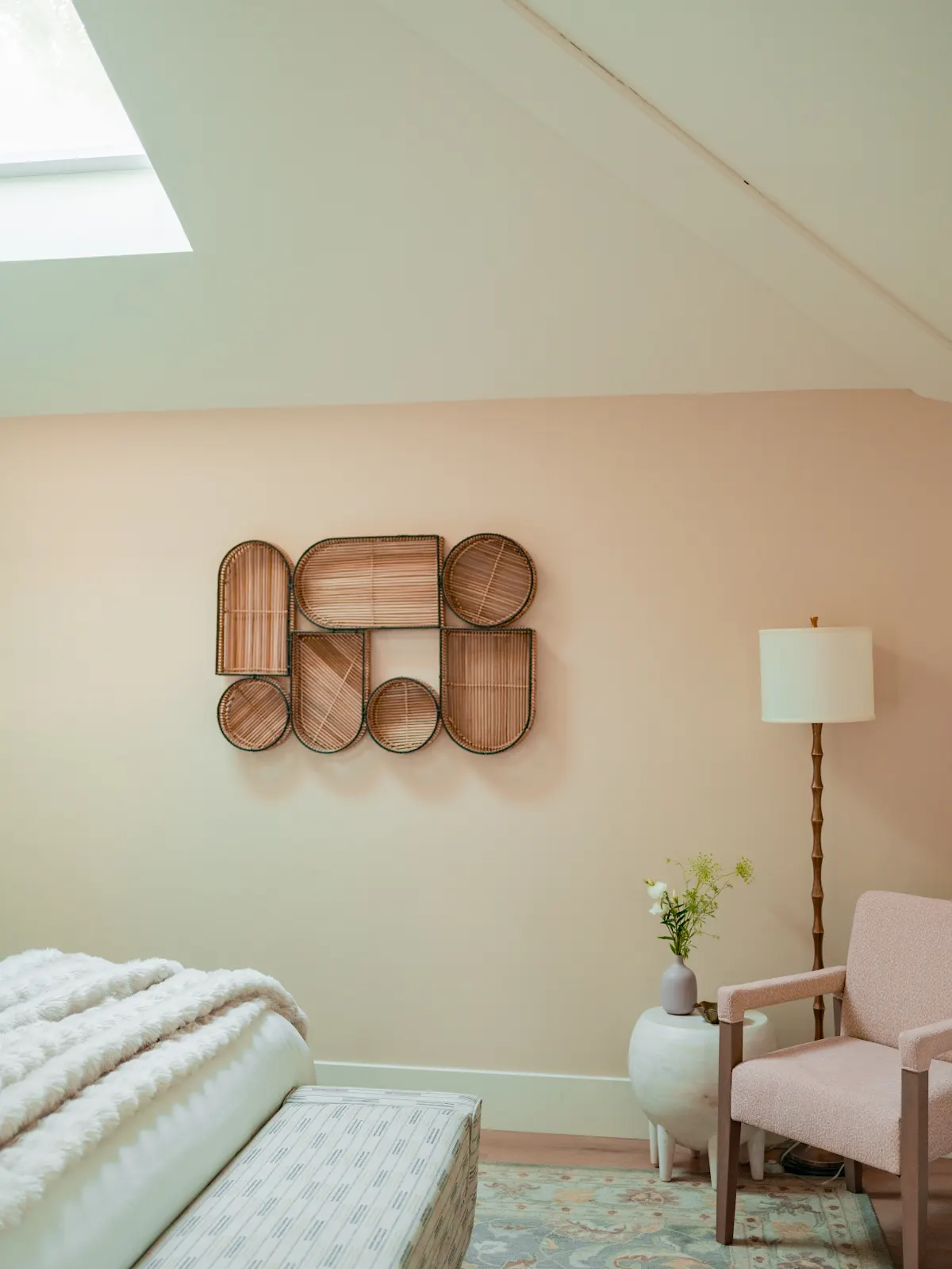 Guest room with a skylight, woven wall decor, and a peach armchair.