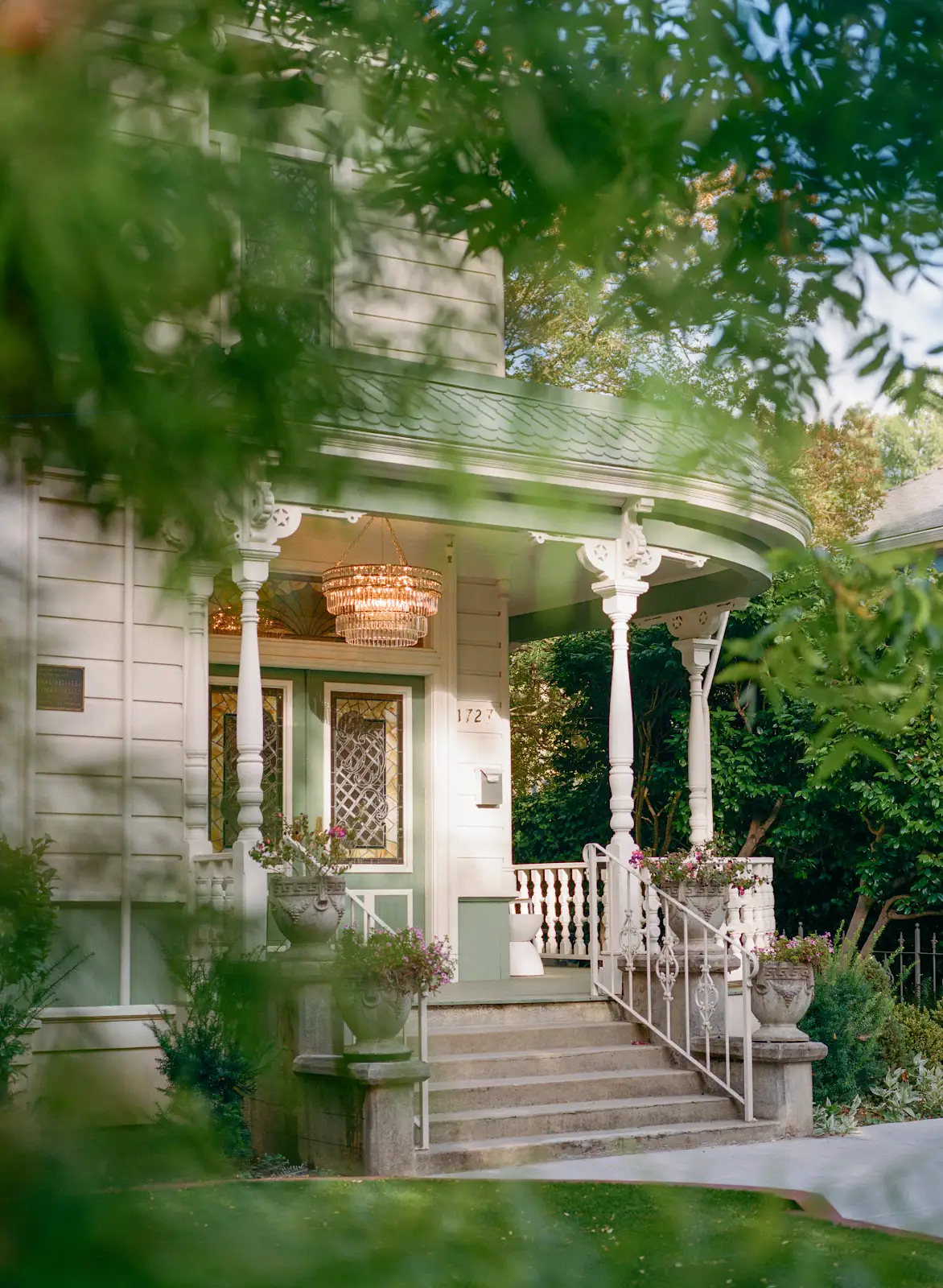The Victorian porch framed by green garden foliage